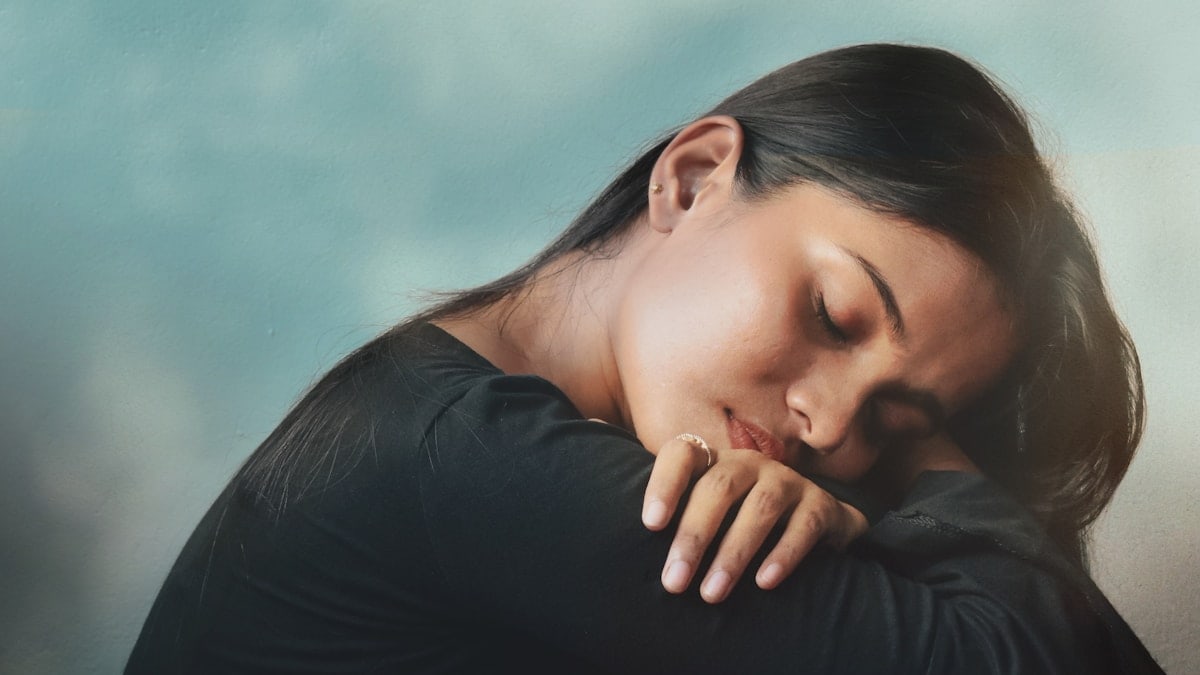 a woman sitting on a couch with her head on her hand