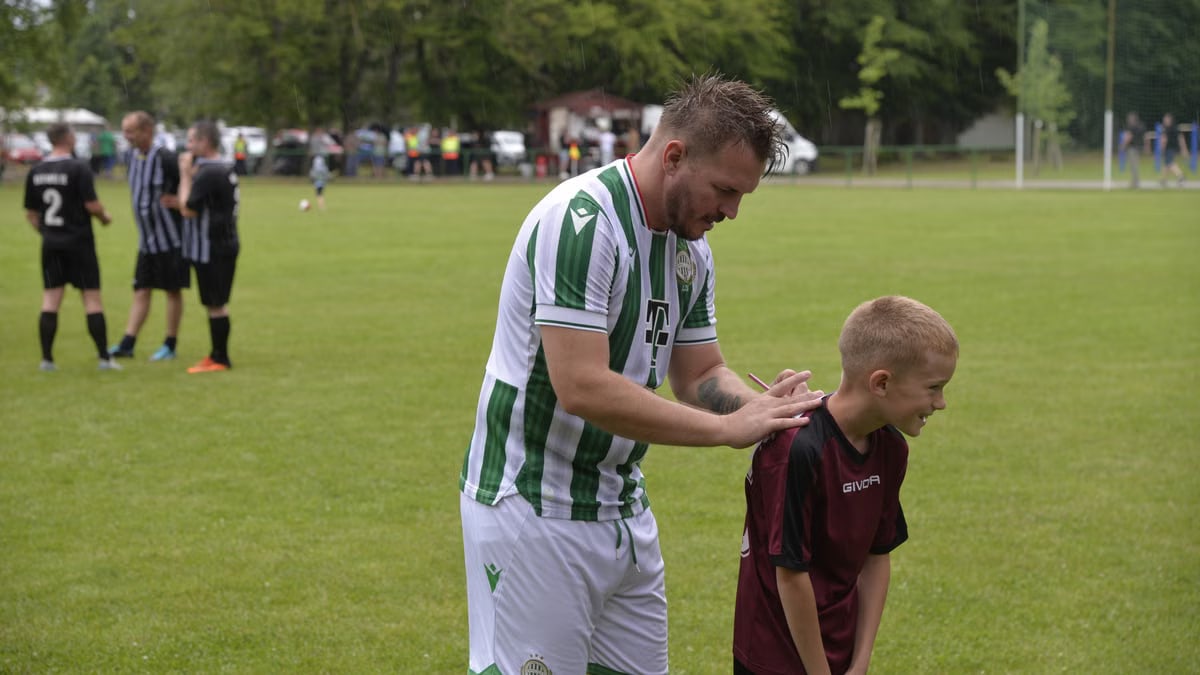 Man and child sharing a moment of camaraderie at a local soccer match in Barabás.